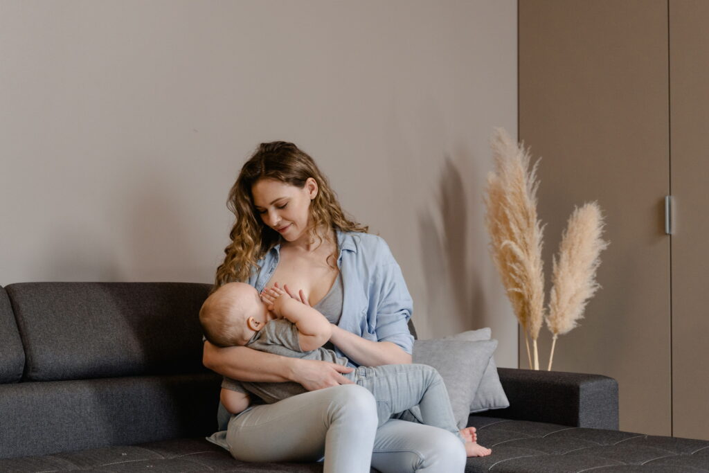 jeune maman allaitant son bébé dans un canapé confortable, sérénité et complicité