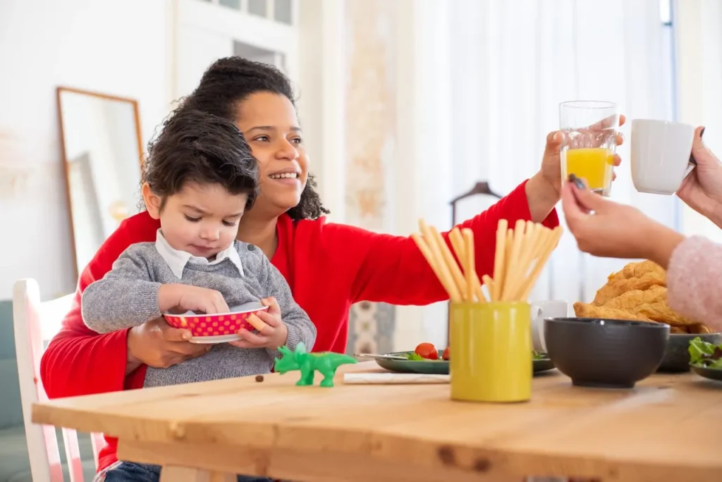 parents qui prennent le petit déjeuner avec bébé à table