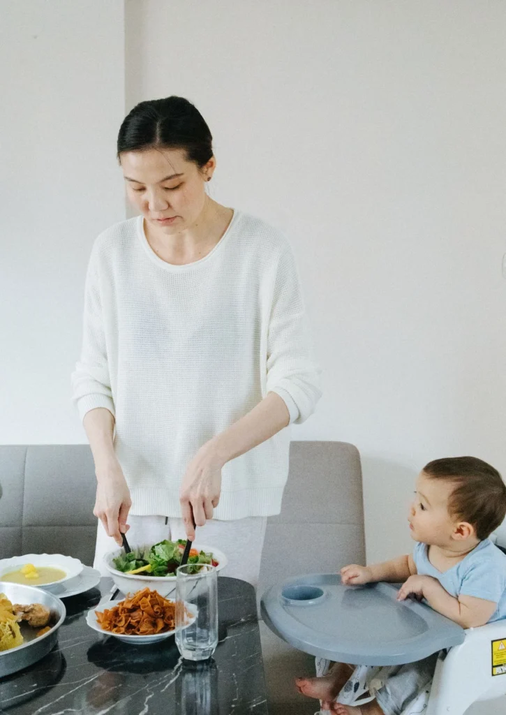 maman qui sert l'assiette à bébé. Assis tous ensemble à table 